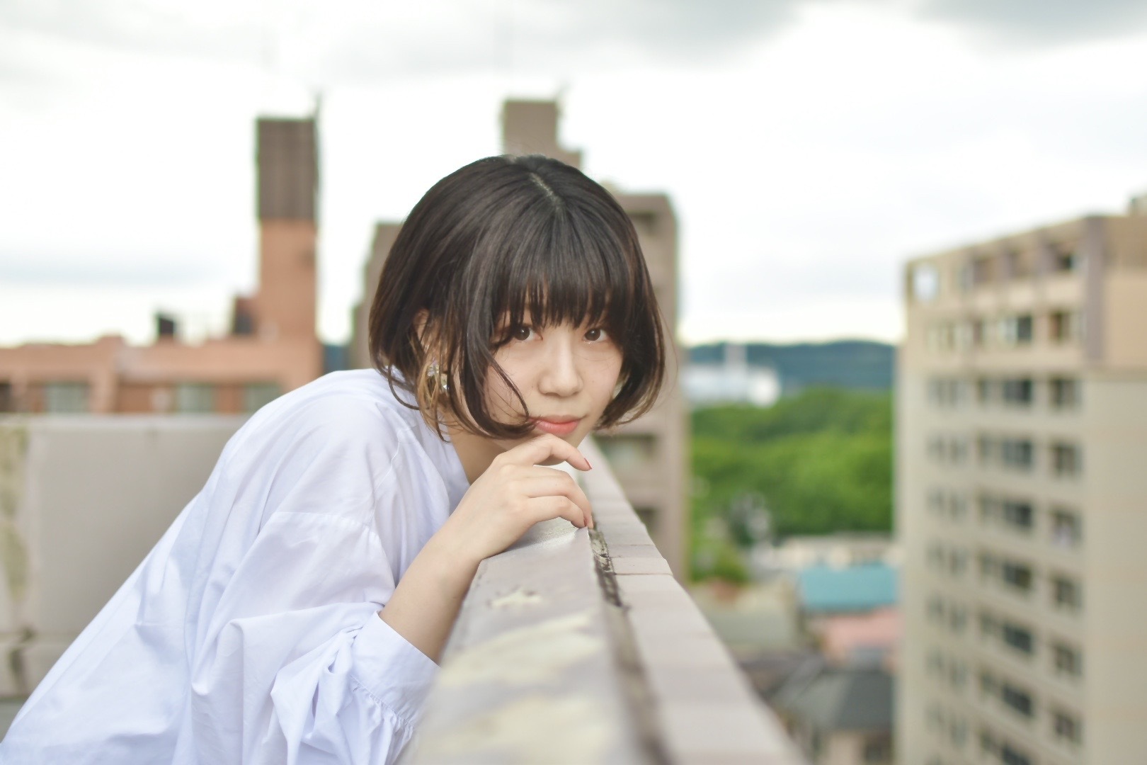 ビルの屋上でこちらを見つめる女性のポートレート撮影